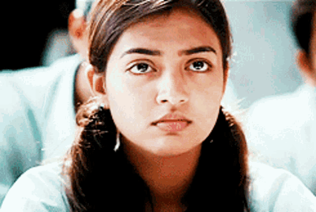 a close up of a girl 's face with a serious look on her face