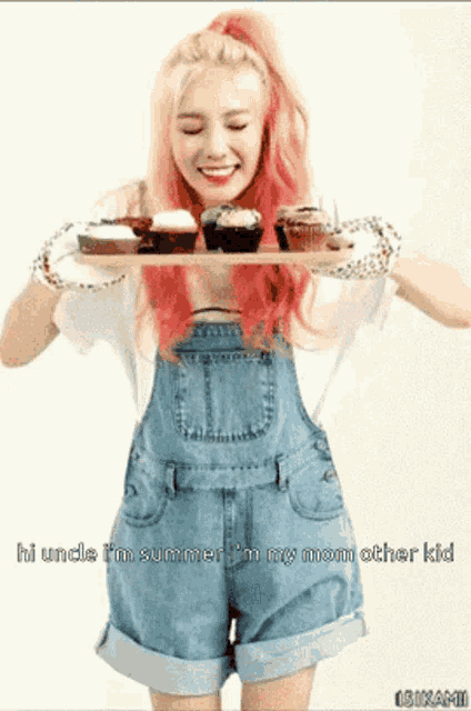 a woman in overalls is holding a tray of cupcakes and says i uncle i 'm summer