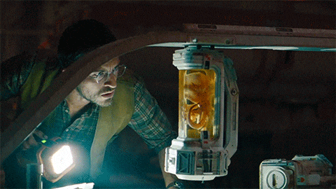 a man in a plaid shirt is looking at a container with a yellow object in it