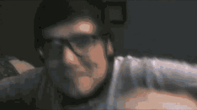 a blurry image of a man wearing sunglasses and a mask