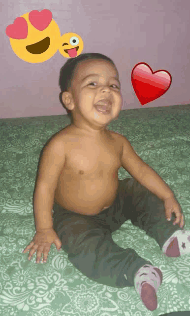 a baby without a shirt is sitting on a bed with hearts and smiley faces around him