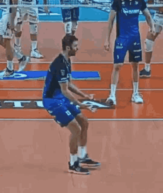a group of men are playing volleyball on a court and one of them is wearing a number 11 jersey .