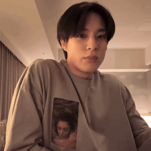 a man wearing a grey shirt with a picture of a woman on the front