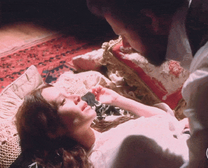 a man and a woman are laying on a bed and the man is looking at the woman 's face