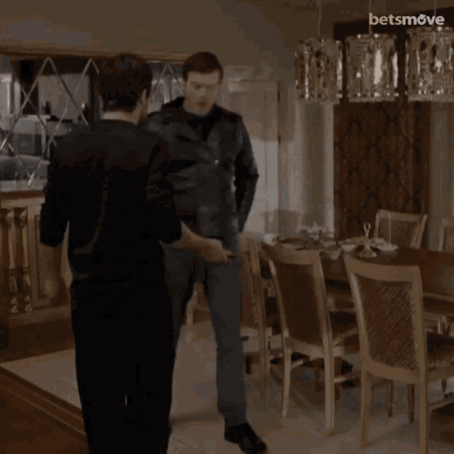 two men are fighting in a dining room with a betsmove logo on the corner