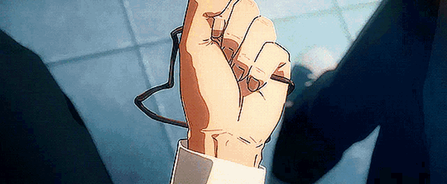 a close up of a person 's hand holding glasses in a fist .