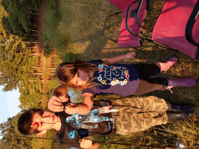 a girl wearing a shirt that says " i love you to the moon and back " holds a fishing rod next to a boy