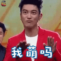 a man in a red jacket applauds in a chinese language