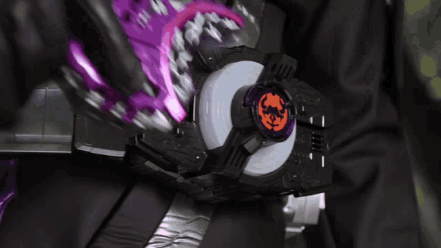 a person is wearing a purple and black belt with a purple and orange item on it
