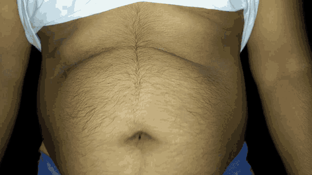 a close up of a man 's hairy stomach with a white shirt on