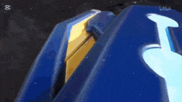 a blue and gold robot is holding a gun in his hands .