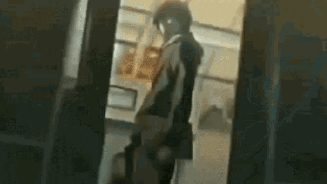 a man in a hooded jacket is standing in a room .