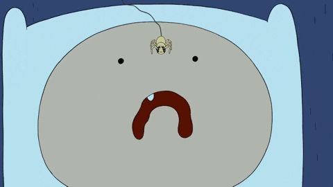 a cartoon character laying in bed with a spider hanging from his head