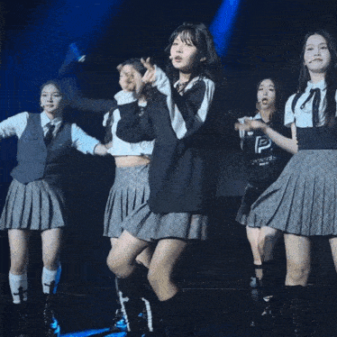 a girl in a black shirt with a bear on it is dancing with other girls
