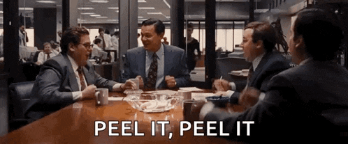 a group of men are sitting around a table with the words " peel it peel it " written on the screen