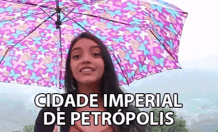 a woman holding a purple umbrella with the words cidade imperial de petropolis below her