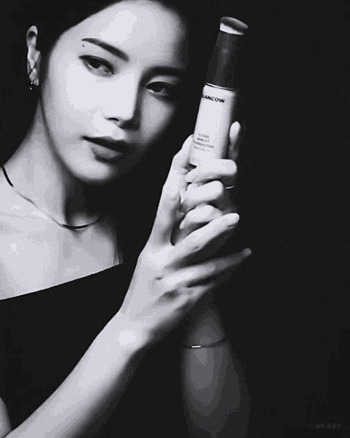 a black and white photo of a woman holding a lancom foundation