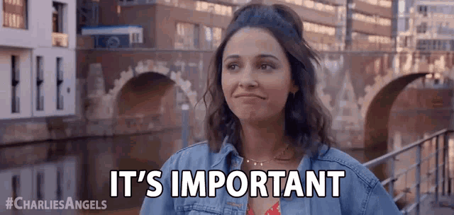 a woman is standing in front of a bridge and says it 's important