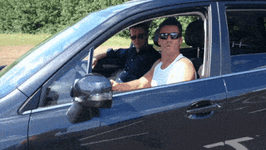 a man wearing sunglasses is sitting in a car with another man