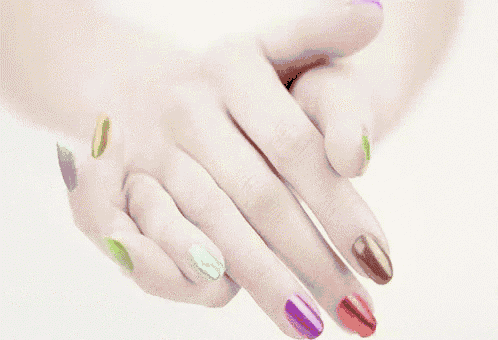 a close up of a woman 's hands with colorful nail polish