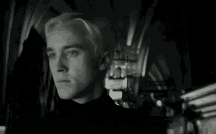 a close up of a man with blonde hair in a dark room .