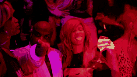 a man in a white suit is pointing at a woman in a red dress