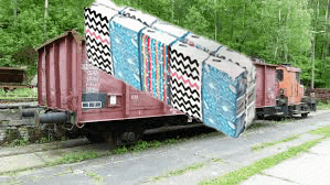 a train car with a quilt on the side