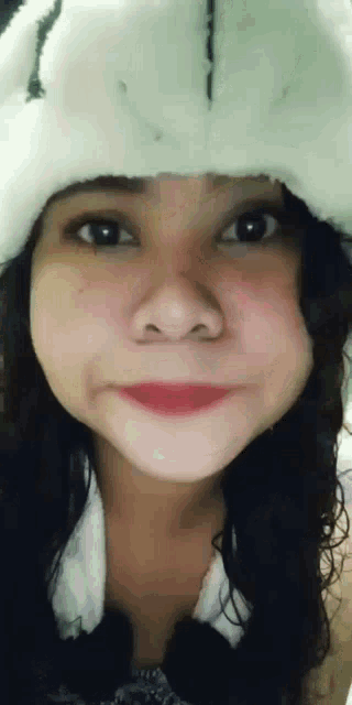 a woman wearing a white hat with a smiley face on it