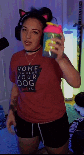 a woman wearing headphones and a red shirt that says home is where your dog is
