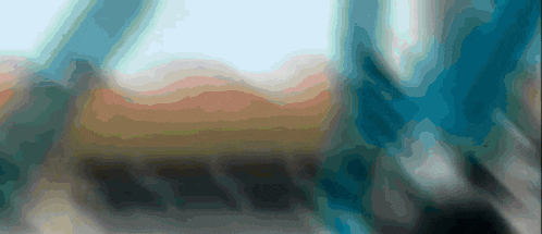 a blurry picture of a landscape with mountains and a blue sky