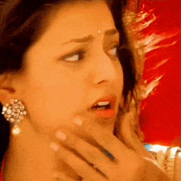 a close up of a woman 's face with her hand on her chin .