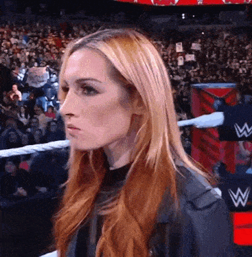a woman with red hair is in a wrestling ring .