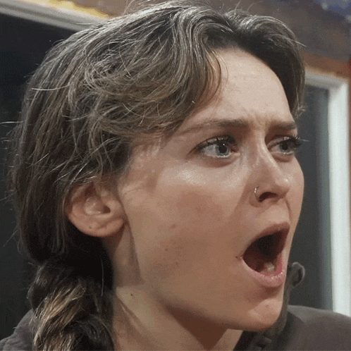 a close up of a woman 's face with a surprised look on her face