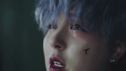 a close up of a person 's face with a tear coming out of it .