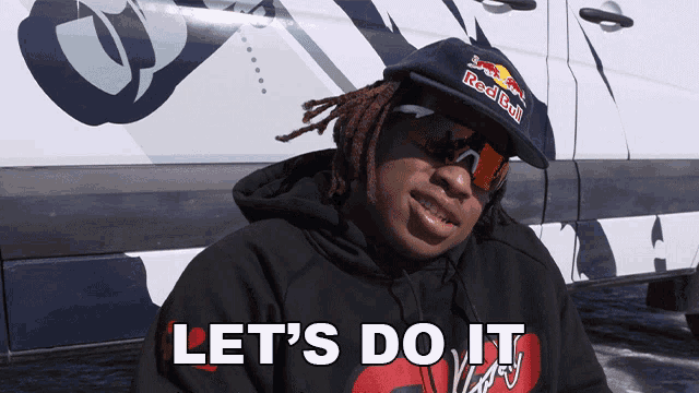 a man with dreadlocks wearing a red bull hat and sunglasses says let 's do it