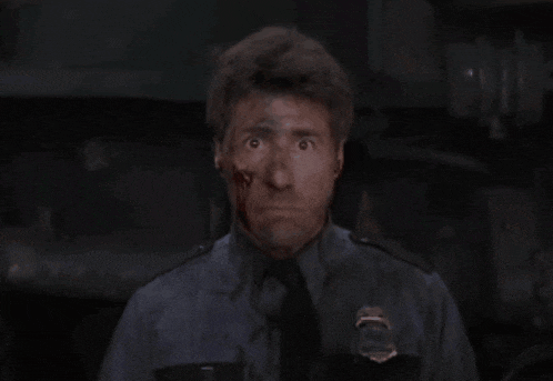 a man with blood on his face is wearing a black shirt and tie