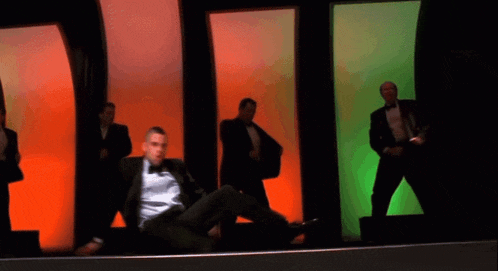 a man in a tuxedo is pointing at something