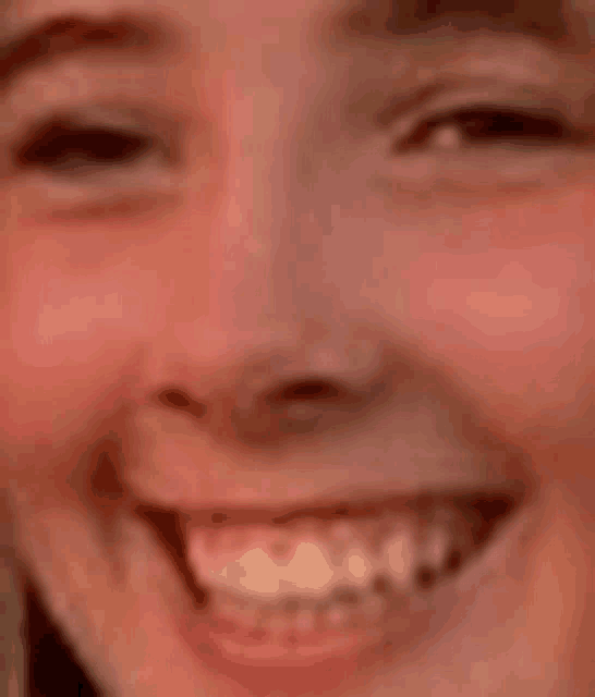 a close up of a woman 's face with a smile on it .