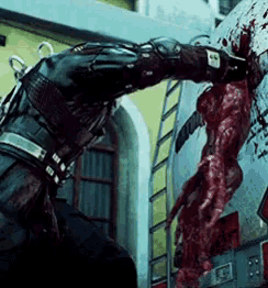 a man in a black suit is standing next to a bloody monster with a ladder behind him