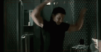 a man is standing in a room with his arms in the air .