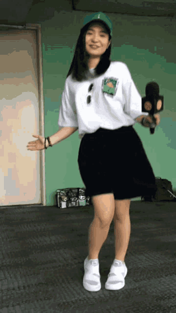a woman in a white shirt and black skirt is dancing