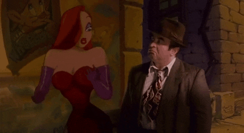 a man in a suit and tie is standing next to a cartoon character .