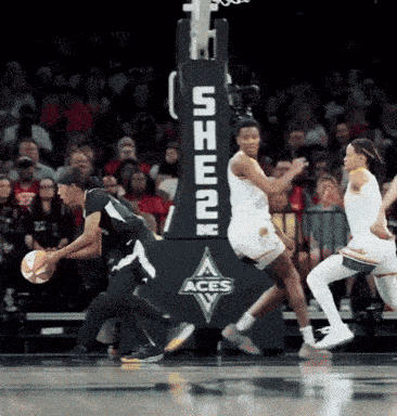 a basketball game is being played in front of a she2k aces banner