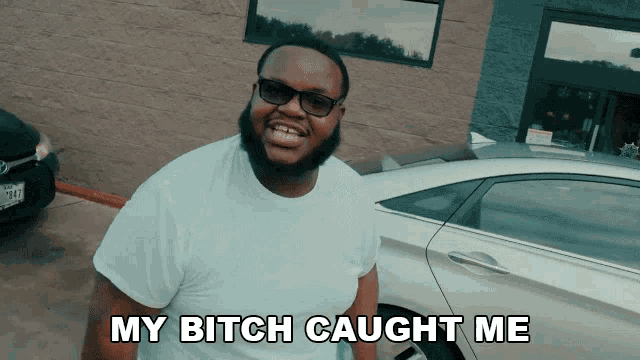 a man standing in front of a car with the words my bitch caught me