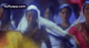a group of people are dancing together in a dark room .
