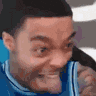 a close up of a man 's face making a funny face while talking on a cell phone .