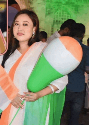 a woman in a white dress is holding a balloon in the shape of an indian flag .