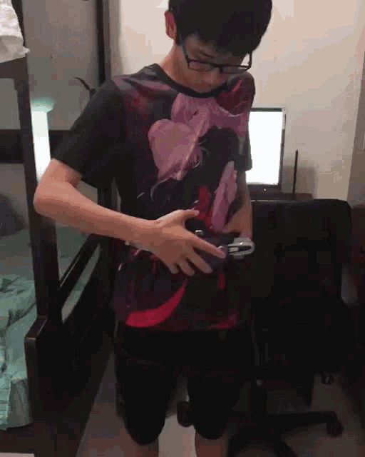 a man wearing glasses and a shirt with flowers on it holds a remote control