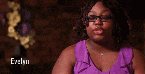 a woman wearing glasses and a purple shirt with the name evelyn on the bottom