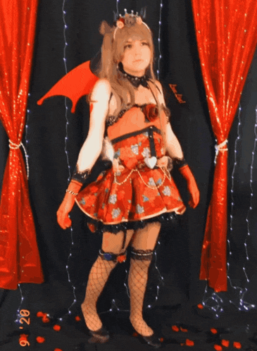 a woman in a red dress stands in front of a red curtain with the date 9 28 on it